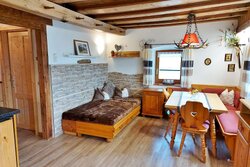 Gemütliches Wohnzimmer mit Essplatz, Sofa und direktem Zugang zum großen Balkon.