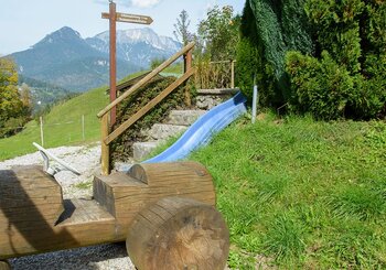 Holzauto und Rutsche in unserem Kinderbereich am Haus